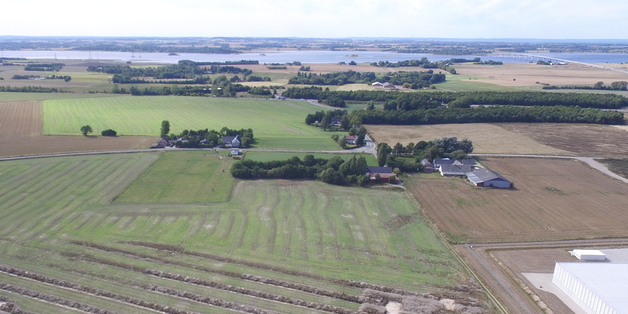 Hjørnet af Fællesmagasinet skimtes i nederste højre hjørne af billedet. Den nye bebyggelse skal ligge umiddelbart sydvest herfor. Foto: Frederikssund Kommune.